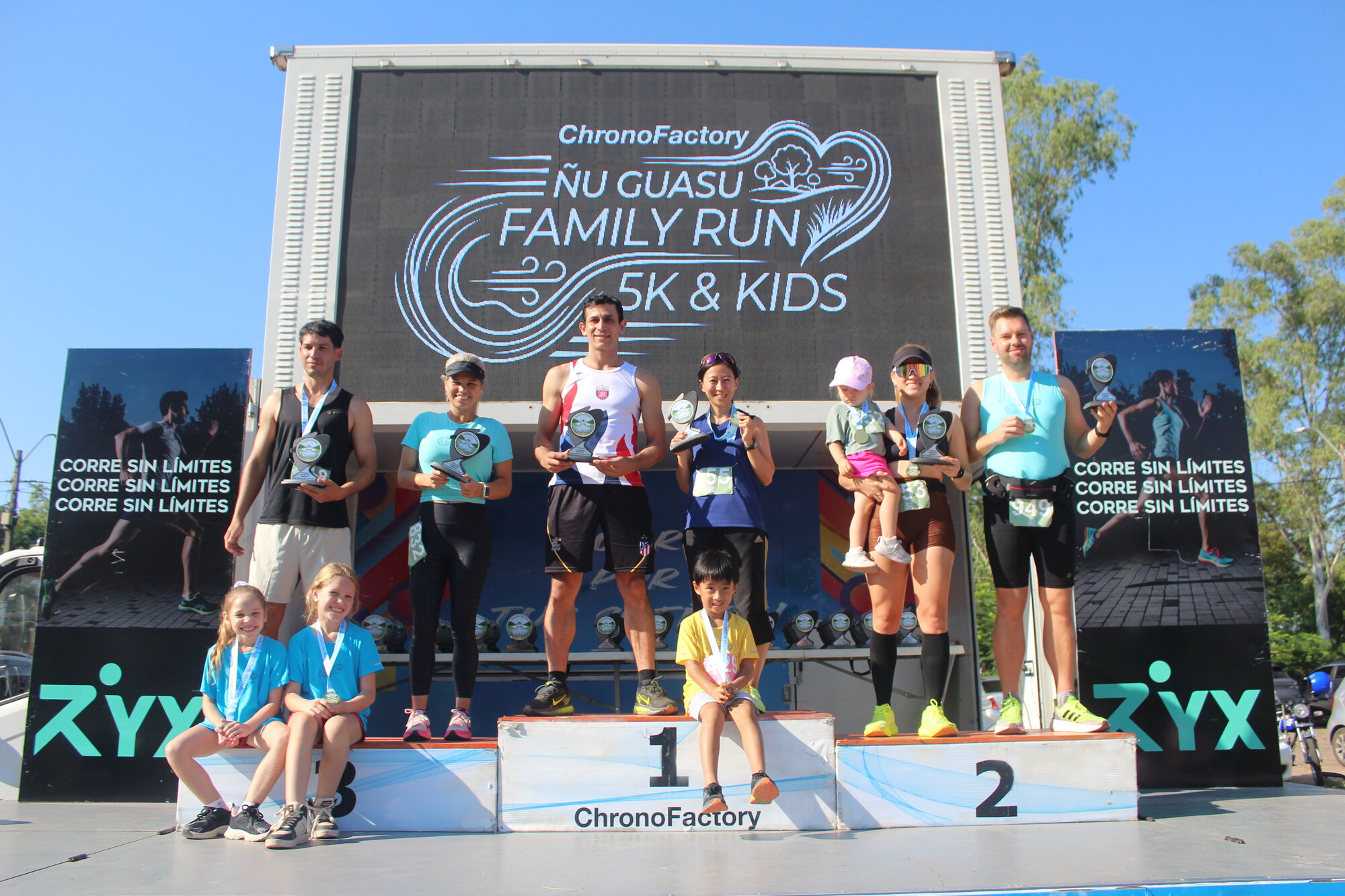 Familia celebrando con medallas en el podio